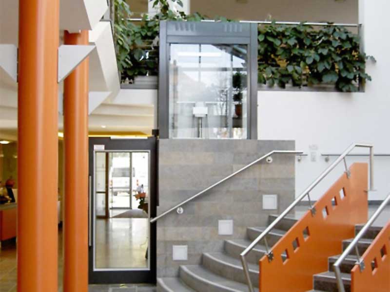 Vertikallift an versetzten Ebenen im Foyer eines öffentlichen Gebäudes