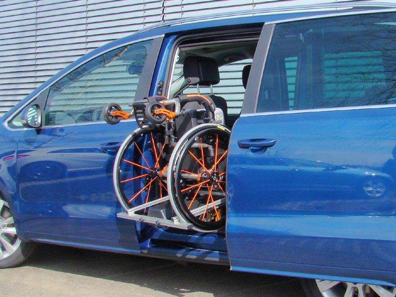 Ladeboy S2 hebt Rollstuhl durch Schiebetür hinter Fahrersitz eines VW Van