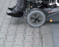 Rollstuhlfahrer an Bordsteinkante Rollstuhlfahrer an Bordsteinkante