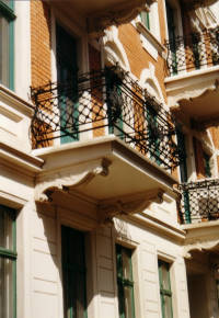 Balkone mit schmiedeeiserne Balkonkonstruktion sind als Schmuck der Fassade zu sehen.
