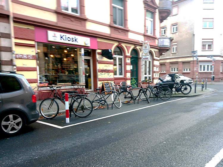 Fahrräder parken auf einem Abstellplatz seitlich auf einer Straße