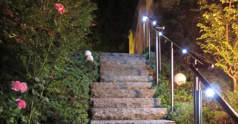Ein in der Nacht beleuchteter Handlauf einer gewendelten Treppe