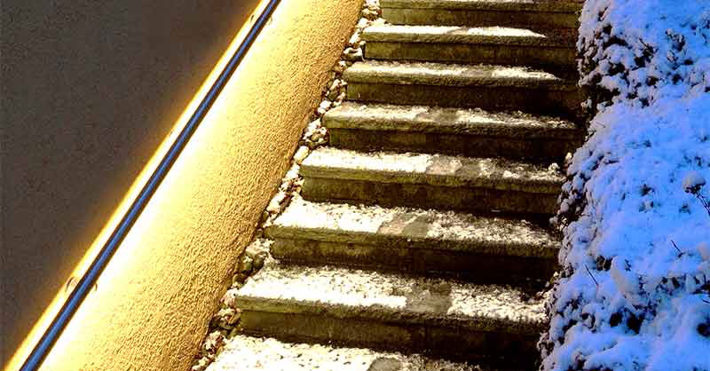 beleuchteter Handlauf an verschneiter Treppe