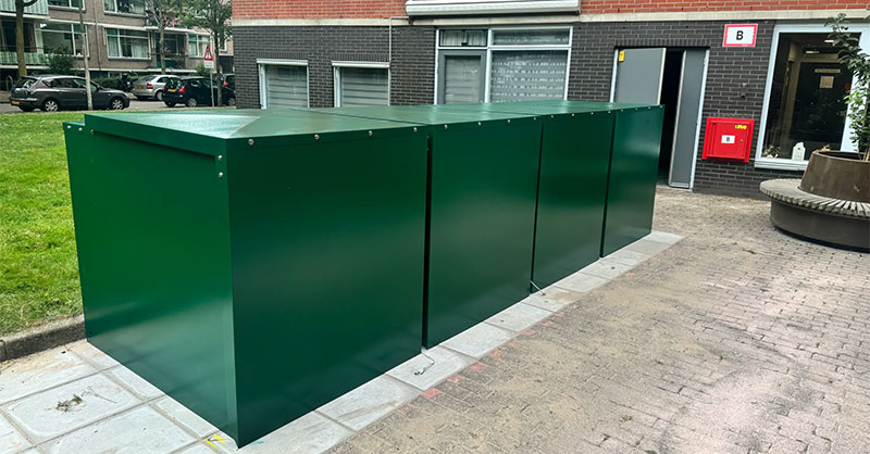 4 Minigaragen für Elektrorollstühle vor einem Mehrfamilienhaus