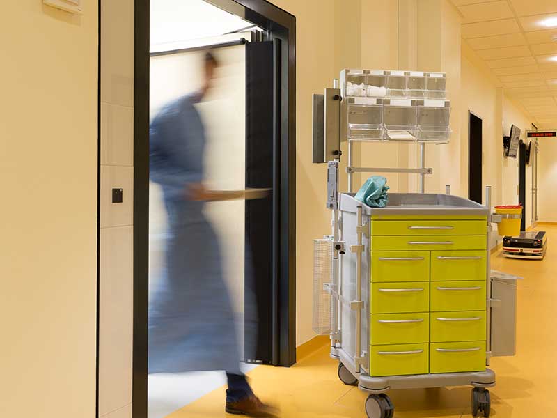 Arzt eilt durch eine Tür im Krankenhaus