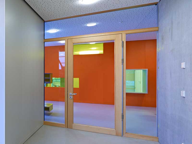Wandverglasung und Glastür am Durchgang in einem Gebäudeflur
