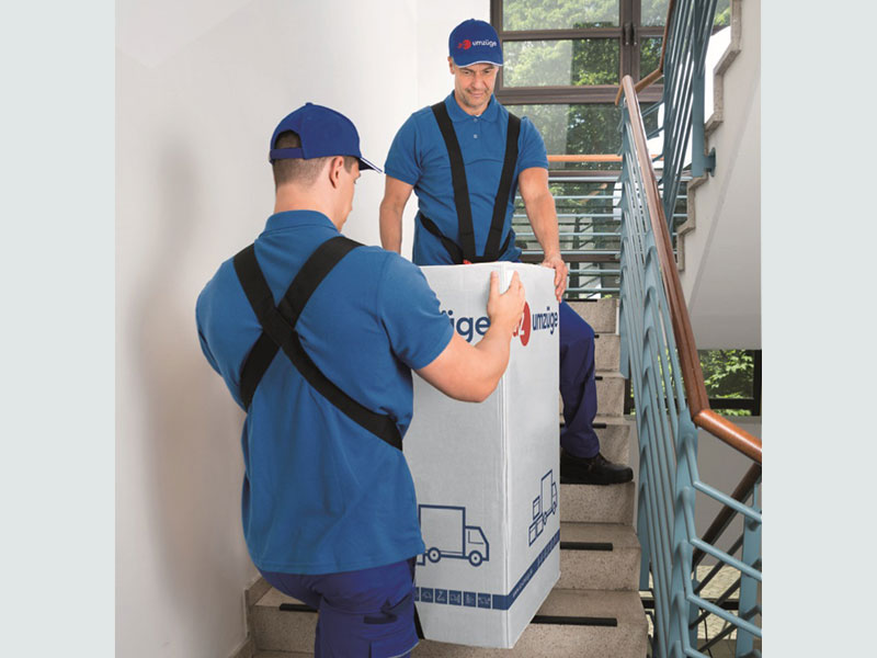 Möbelpacker tragen schwere Last die Treppe hoch