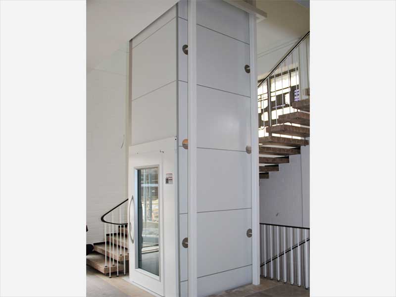 Homelift in weißem Stahl/Glasschacht an Treppe Einfamilienhaus