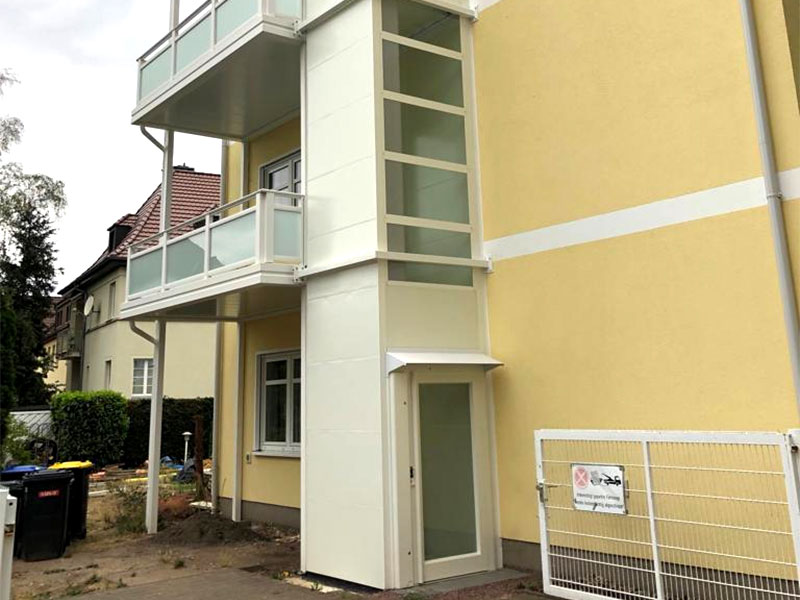 Ein Aufzug an der Fassade eines Mehrfamilienhauses