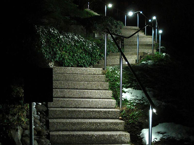 Ein in der Nacht beleuchteter Handlauf einer gewendelten Treppe