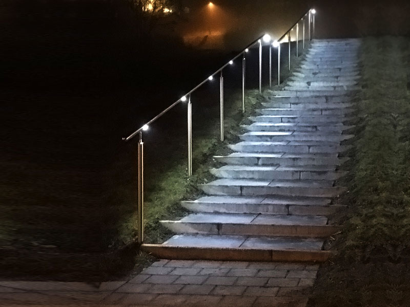 In der Nacht beleuchteter Handlauf einer geraden Außentreppe
