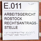 Türschild mit Brailleschrift und tastbaren Buchstaben