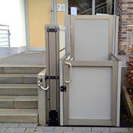 Rollstuhl-Hebebühne an einer Treppe eines öffentlichen Gebäudes im Außenbereich