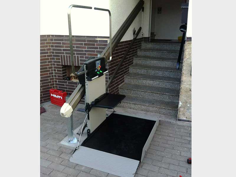 Treppenplattformlift für Rolstuhl zur Überwindeung einer Außentreppe am Eingang eines privaten Wohnhauses