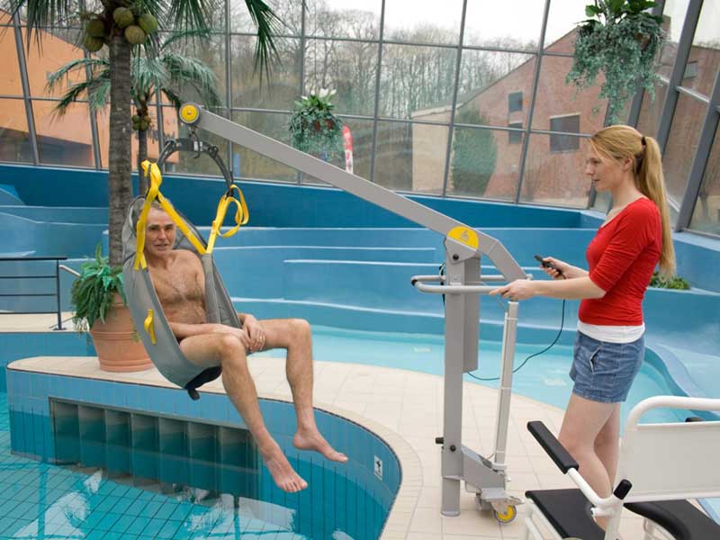 Der mobiler Schwimmbadlift hebt den Nutzer mit einem Hebetuch aus dem Schwimmbaecken