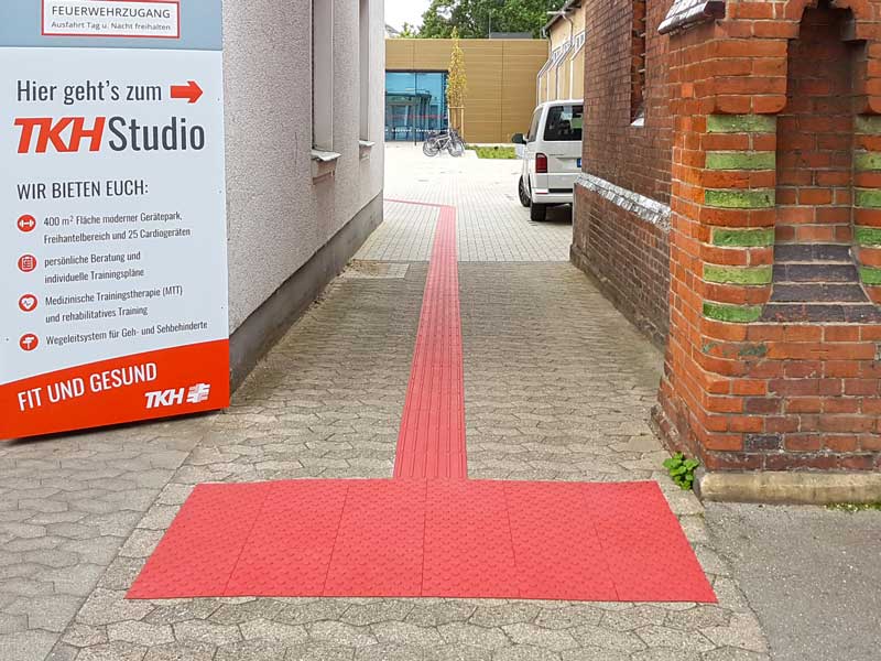Rippen- und Noppenplatten rot auf einem Gehweg im Außenbereich