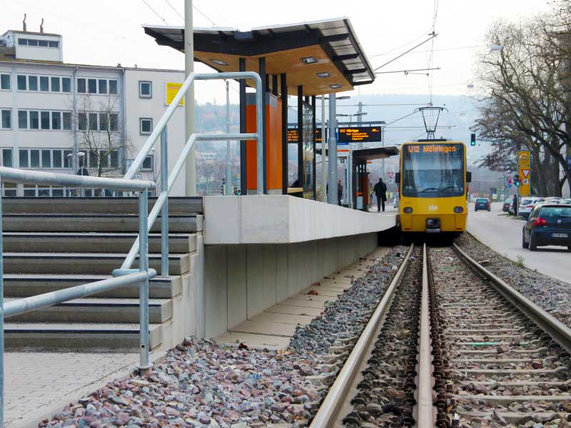 Straßenbahn hält an überdachtem Hochbahnsteig in Stuttgart
