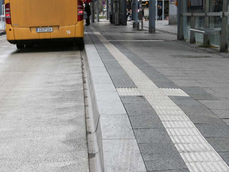 Bushaltestelle mit Blindenleistreifen und Haltestellenbord
