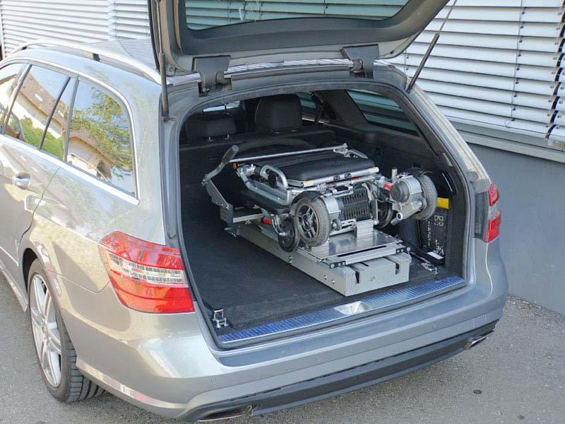 gefalteter Rollstuhl liegt im auf Verladesystem im Kofferraum eines Mercedes e-Klasse Kombi