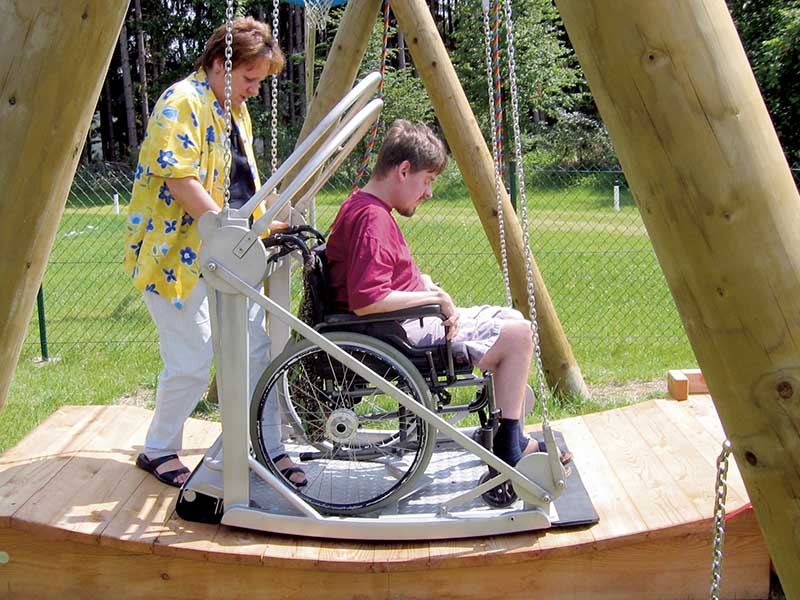 Kind im Rollstuhl auf Schaukel