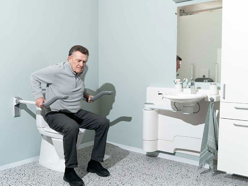 Gebrauch der Toilettenst&uuml;tzgriffe, um sich vom Sitzen hochzustemmen