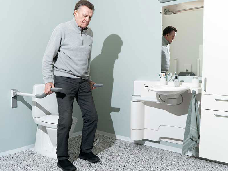 Mit Hilfe der Toilettenst&uuml;tzgriffe kommt jemand vom Sitzen in die Stehposition