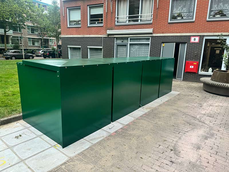 4 Minigaragen f&uuml;r Elektrorollst&uuml;hle vor einem Mehrfamilienhaus