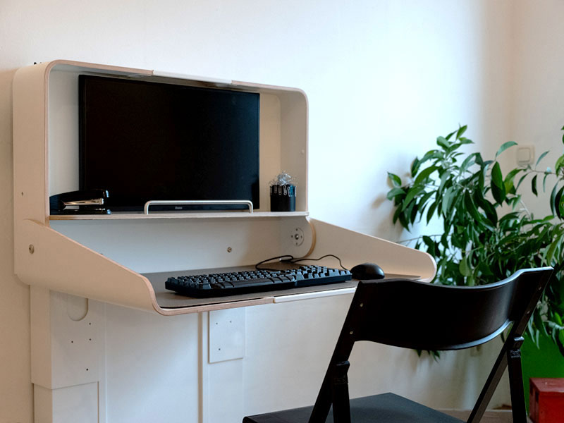 aufgeklappter Schreibtisch mit Tastatur und Monitor