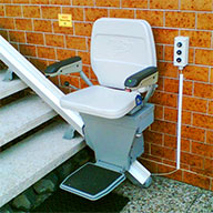 gebrauchter Treppensitzlift an einer geraden Treppe im Außenbereich