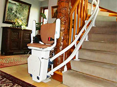 Treppensitzlift an einer gewundenen Treppe in einer Wohnung
