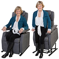 Pflege-Sessel mit grauem Bezug. Frau bedient die Aufstehmechanik, die sie in stehende Position hebt.